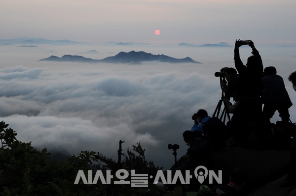 이내 바닷물 속에서 갓 건져낸 것처럼 촉촉한 태양이 운해와 엉켜 있다가 완전히 떠올랐다. 북한산의 일출을 담기 위해 사진애호가들의 모습도 분주하다 ⓒ 최기영